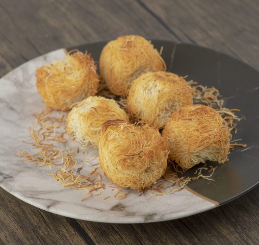 Plate of delicious nest pastries placed on wooden table. High quality photo